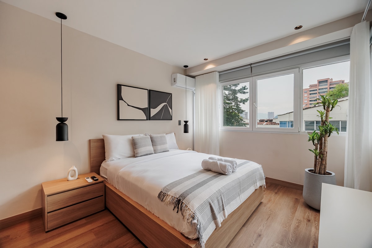 “Un dormitorio bellamente diseñado con una cama tamaño king y un armario grande. Luminoso, elegante y cómodo, ofrece un ambiente sereno con detalles refinados y una excelente iluminación para una estadía relajante”.