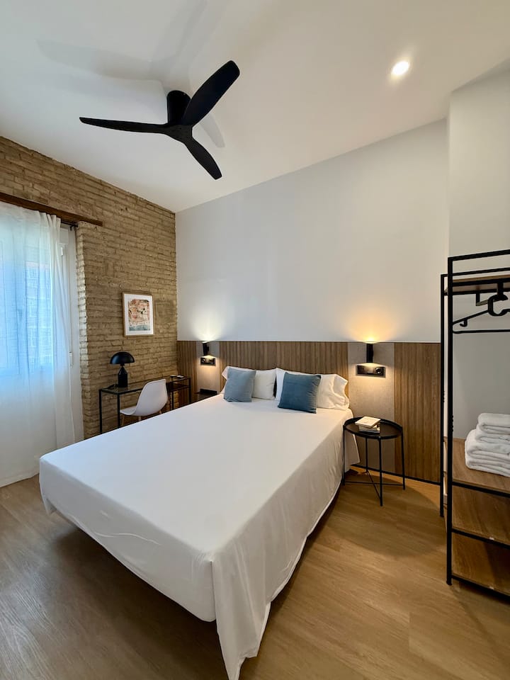 DORMITORIO 2: Cama doble, zona de escritorio, TV Smart, armario para guardar y colgar prendas, persiana enrollable con cortina liviana para mayor privacidad, radiador y ventilador de techo.