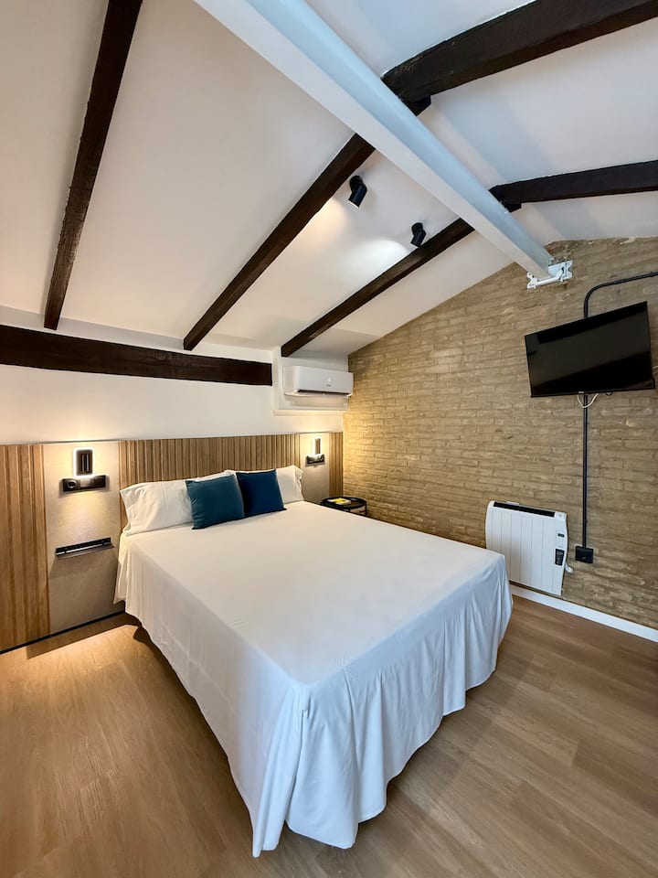 DORMITORIO 3: Cama doble, baño en-suite, zona de escritorio, TV Smart, radiador y aire acondicionado tipo split frío/calor. Se provee ropa de cama completa, con una toalla grande y una pequeña por huésped.