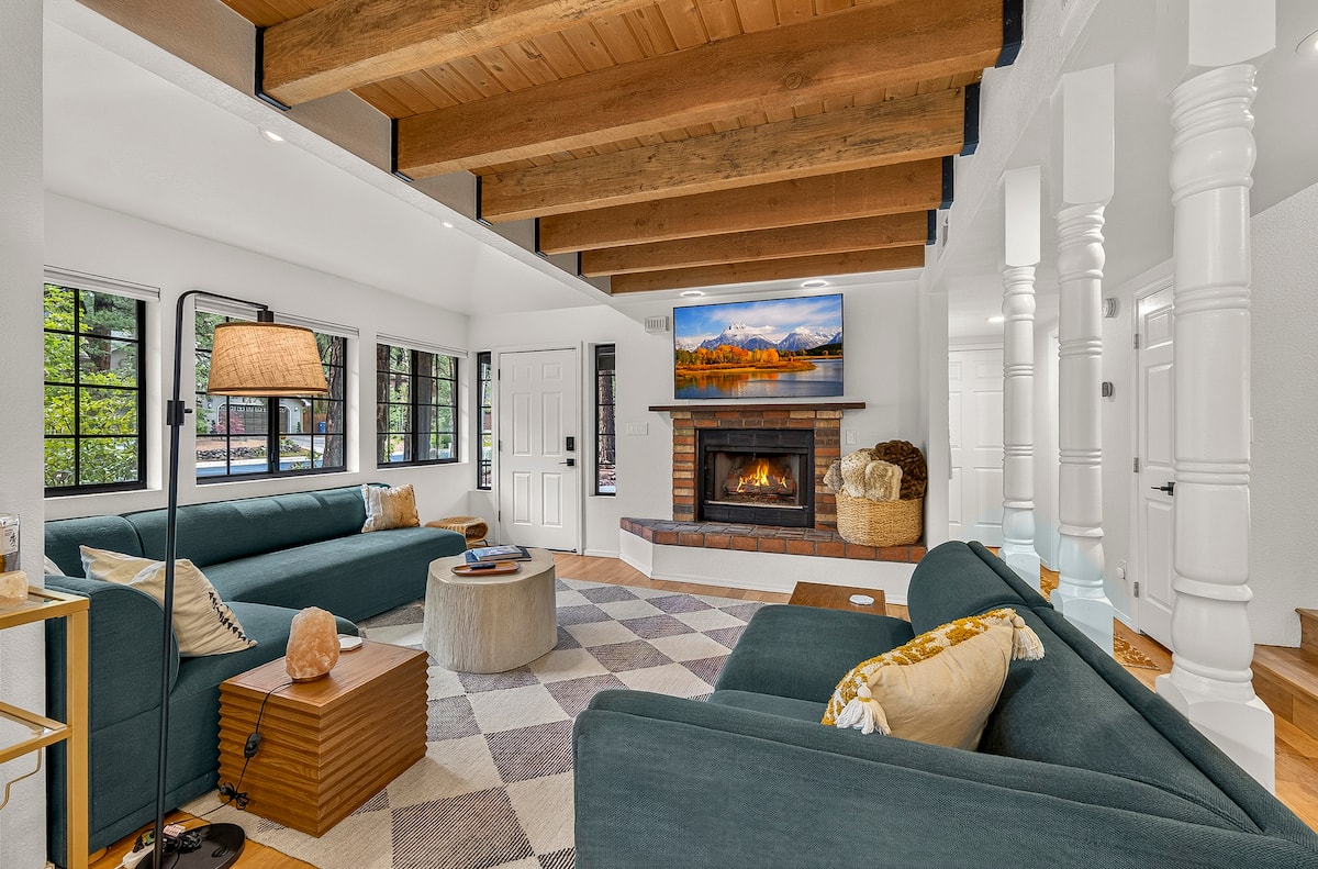 Pine and Light living room with teal sofas, timber ceiling, and fireplace