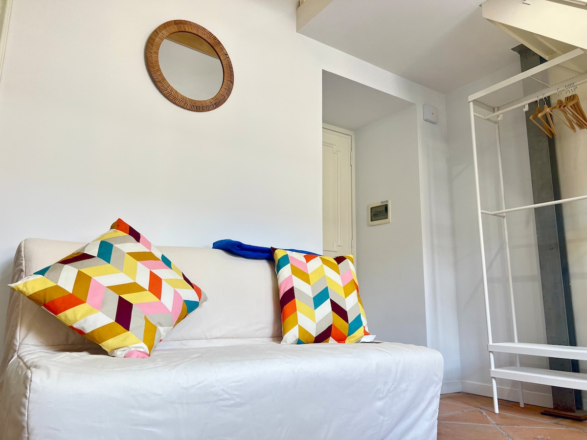 Lichte woonkamer met comfortabele slaapbank en kleurrijke details. Perfect om te ontspannen na het verkennen van Rome. Ideaal voor gezinnen of vrienden, op korte loopafstand van het Colosseum, de keizerlijke fora en station Termini.