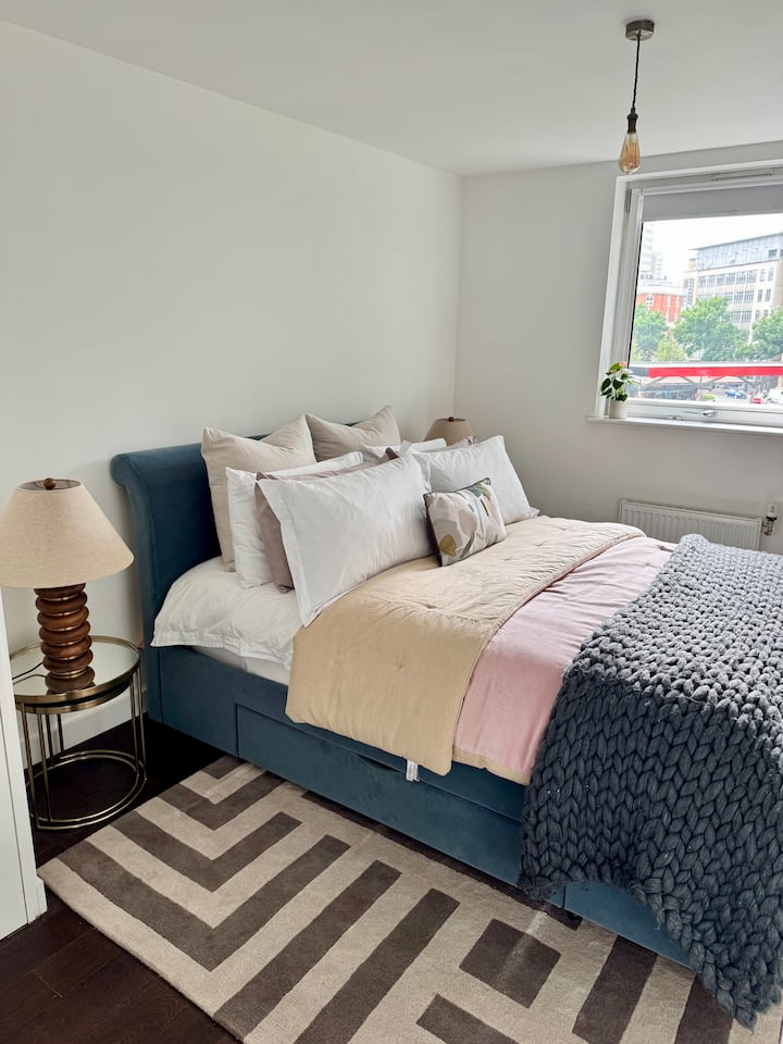 Una habitación luminosa y acogedora con una lujosa cama tamaño king, suaves sábanas en capas y mucha luz natural: un espacio tranquilo y cómodo para relajarte y recargar energías durante tu estancia.