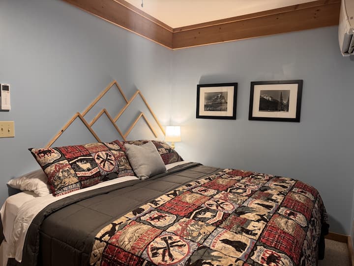 Dormitorio en el nivel inferior con cama tamaño king y baño privado en suite.