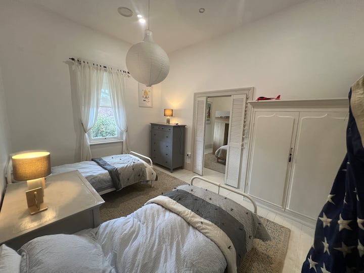 Chambre double lumineuse avec de nombreux rangements. Les persiennes de la plantation peuvent être fermées pour séparer les deux chambres ou ouvertes pour créer un espace plus grand pour la famille. 