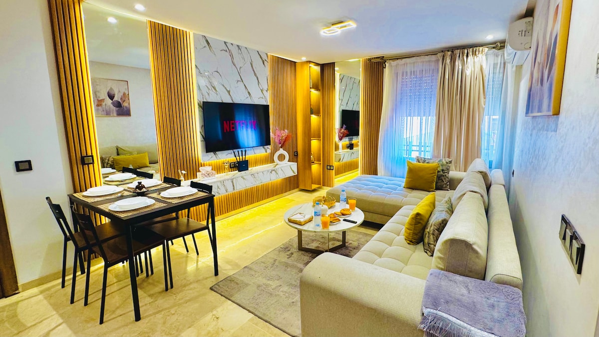 Svetlá obývačka s mramorovou stenou, útulnou pohovkou a inteligentnou televíziou (vrátane Netflixu)
