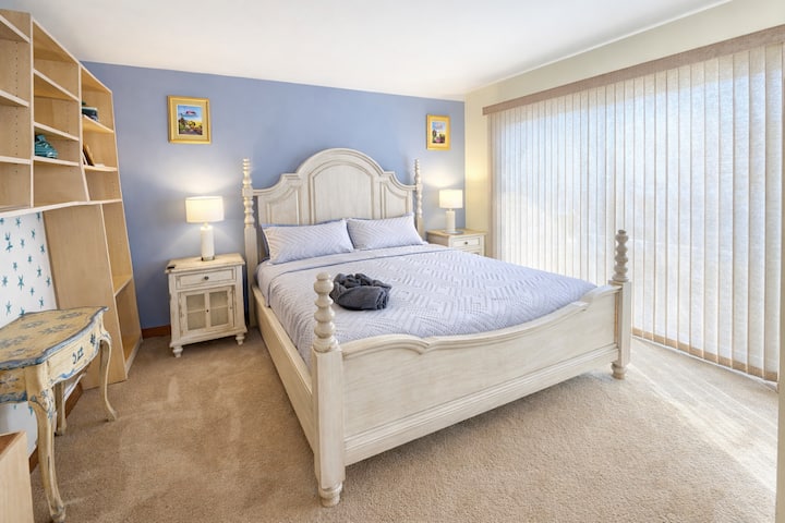 - Rest easy in a bright bedroom with natural sunlight  
- Elegant queen bed and calming coastal décor  
- Peaceful retreat for a relaxing night’s sleep  