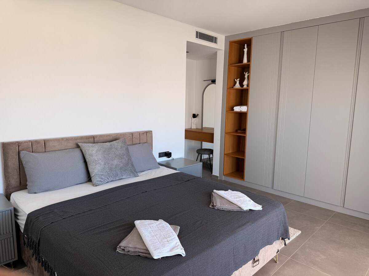 Grote slaapkamer met kingsize bed, eigen badkamer en groot balkon met panoramisch uitzicht op zee.