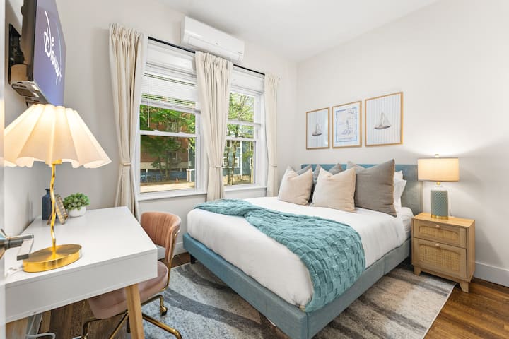 Urembo wa kisasa hukutana na starehe nzuri katika kitanda cha Malkia chenye maumbo mengi, matuta laini, na vivutio vya dhahabu vilivyooanishwa na mandhari ya bluu ya bahari yenye kutuliza. Sehemu ya kufanyia kazi ya kujitegemea iliyo na kiti maridadi, chenye starehe na meza inaongeza kazi na ustadi.