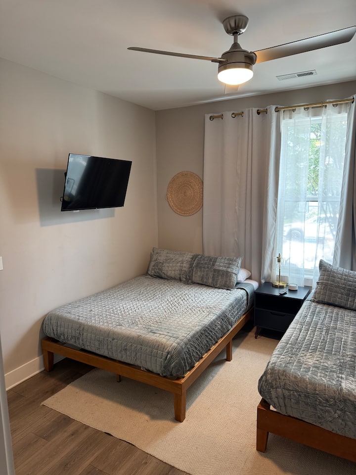 Two queen beds in a spacious room with a tv and an en suite bathroom.
