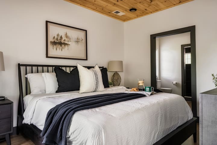 Plongez dans le luxe pur avec ce somptueux lit king-size! Détendez-vous dans l'élégante chambre principale, dotée de draps frais, de plafonds en bois chaleureux et d'une salle de bain attenante. Parfait pour une nuit de sommeil réparatrice après une journée d'exploration.
