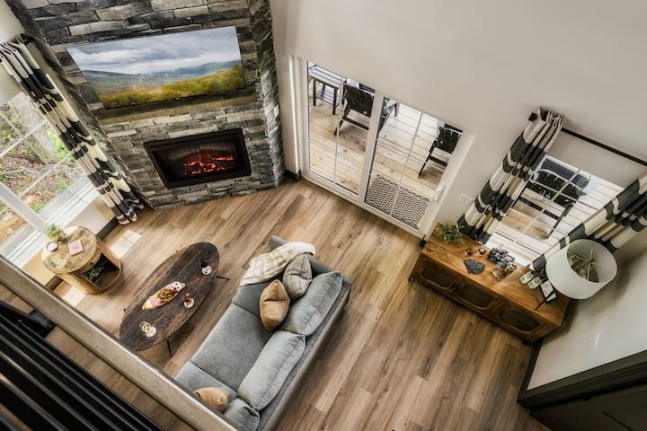 Profitez de ce salon lumineux dans le chalet, avec ses hauts plafonds, son canapé moelleux et son accès direct à la terrasse extérieure. L'endroit idéal pour se détendre et regarder vos films préférés en continu