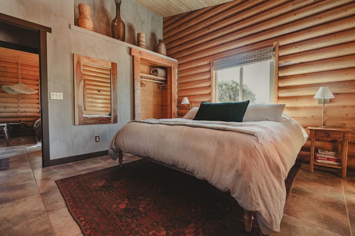 The king bed is dressed in 100% linen and Supima cotton sheets. The rug underneath is from the early 1900s. Its imperfections makes it perfect. Brass reading lamps illuminate the words that draw in dreams. Room darkening shades are provided.