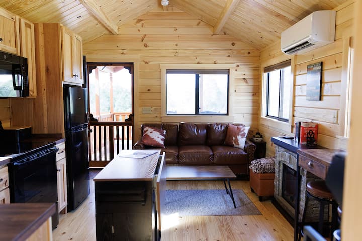 Uvoľnite sa v tejto útulnej obývačke s inteligentným televízorom, kozubom a vstavaným úložným priestorom na hry (gauč a taburetka) – ideálne miesto na filmové večery alebo malú priateľskú súťaž.