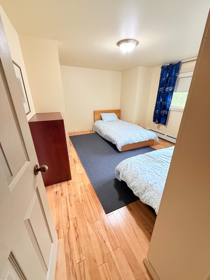 غرفة نوم في الطابق الرئيسي بسريرين مفردين