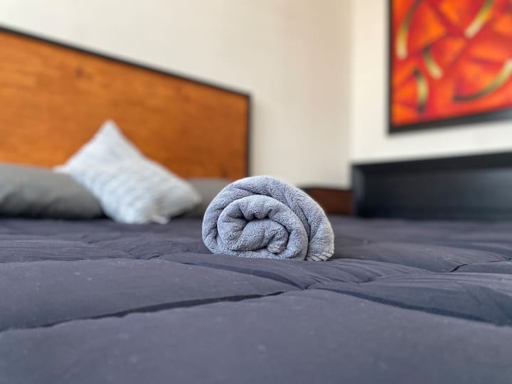 Მისასალმებელი შეხება დედოფლის ზომის საწოლზე, რომელიც იდეალურია დაბინავების მომენტიდან დასასვენებლად.