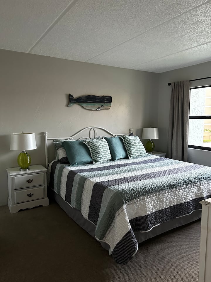 ОСНОВНА СПАЛНЯ С НОВ МАТРАК ЗА ЛЕГЛО КИНГ.  ВАШИЯТ ИЗГЛЕД ОТ ПРОЗОРЕЦА В ПЪРВИЧНИЯ ПО ПЛАЖНАТА РАМПА