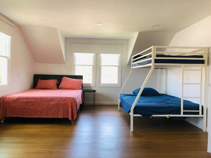 Bright, spacious bedroom with a queen bed and a twin-over-full bunk bed, offering plenty of room to relax and unwind.