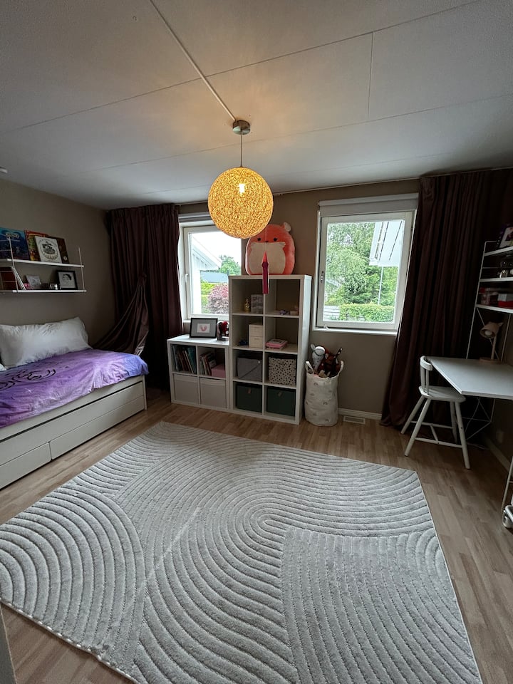 Spavaća soba s dva jednostruka kreveta, od kojih je jedan na izvlačenje ispod kreveta. Ima knjiga, rukotvorina i Lego kockica.
