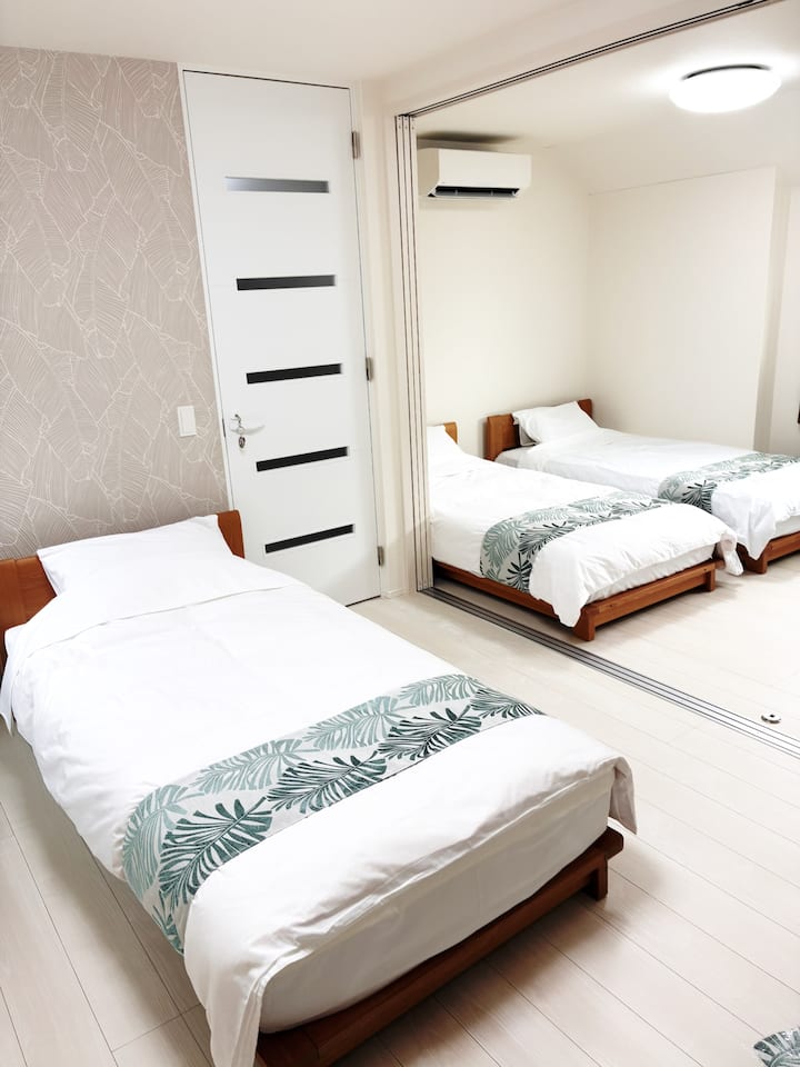こちらのお部屋は、ベット１台、ソファにもなるマットレス２台を設置しています。３枚引き戸を開けた状態のお写真。
ベッドは飛騨の天然木家具と、日本ベッド社製「ビーズポケットマットレス」を採用。コネクトルームは、3枚の引き戸を閉めることで空間を仕切ることができます。  
ご家族で広々とくつろいだ後は、引き戸を閉めてそれぞれの空間で落ち着いてお休みいただけます。  
旅のひとときを、開放感と静けさの両方でお過ごしください。