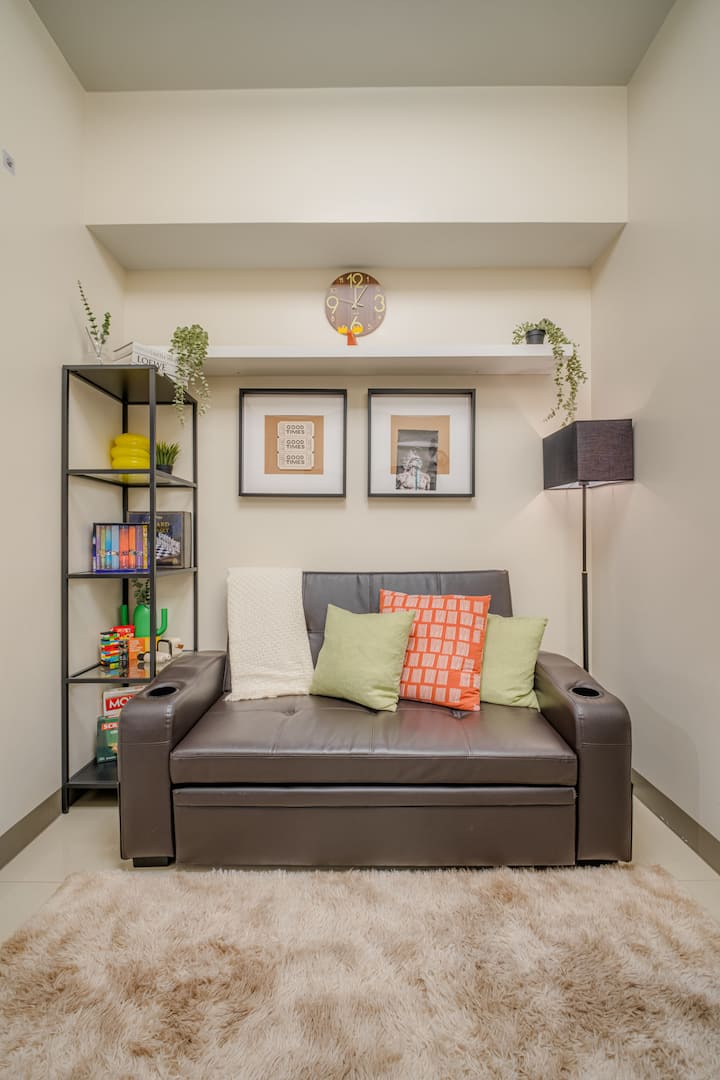 Acogedora sala de estar con sofá cama, cojines y mantas, televisor inteligente de 50" con Netflix, ajedrez de Harry Potter, libros, cartas temáticas y para beber, Jenga, juegos de mesa (Uno, Monopoly, Scrabble), además de micrófonos de karaoke y altavoz para noches divertidas.