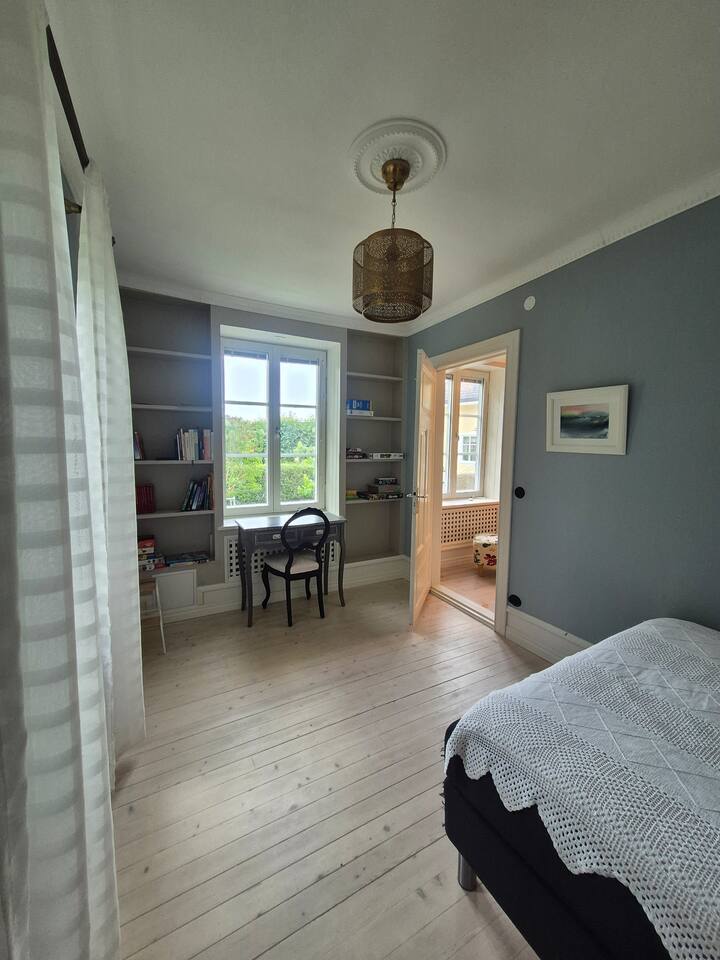 Spavaća soba s malim radnim stolom. Knjige, slagalice i igre za djecu. Pogled na bravu. 