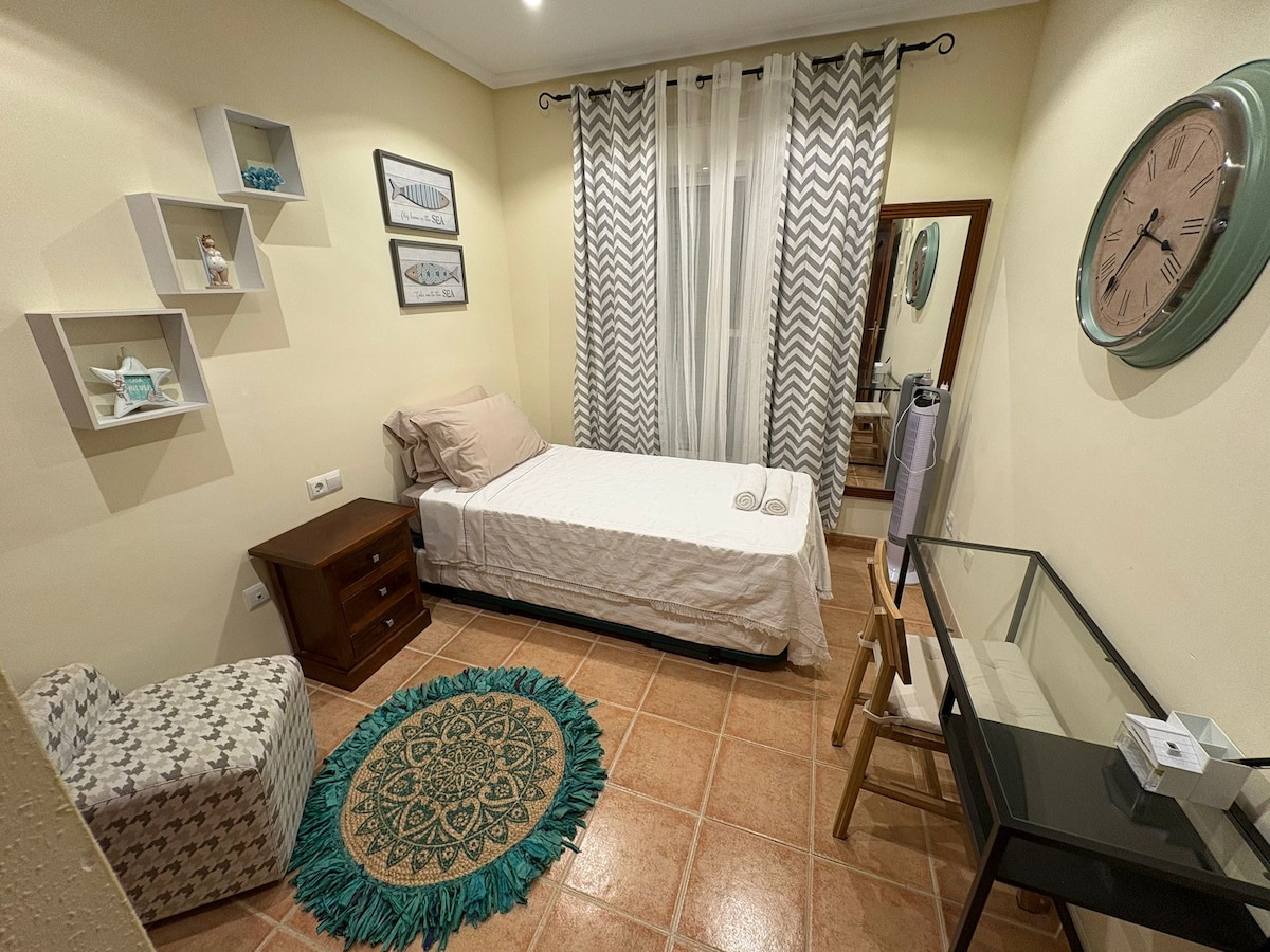 غرفة نوم في الطابق الأرضي. سرير مع سرير صغير قابل للسحب ومكتب. يحتوي على مروحة وخزانة كبيرة ومرآة. 