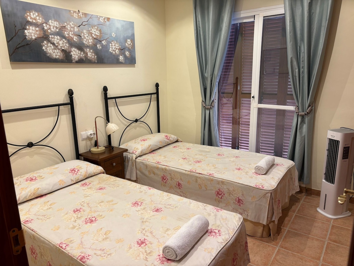 غرفة نوم في الطابق الثاني مع سريرين مفردين ومروحة مع هواء بارد. خزانة كبيرة على طول الجدار بأكمله. 