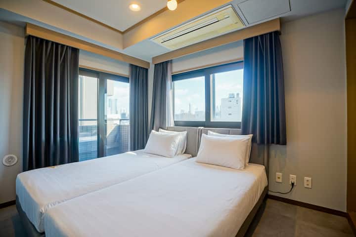 ห้องนอนแยกต่างหากตรงข้ามลานบ้านพร้อมเตียงแฝดออกแบบมาเพื่อการพักผ่อนที่เงียบสงบและเป็นส่วนตัว