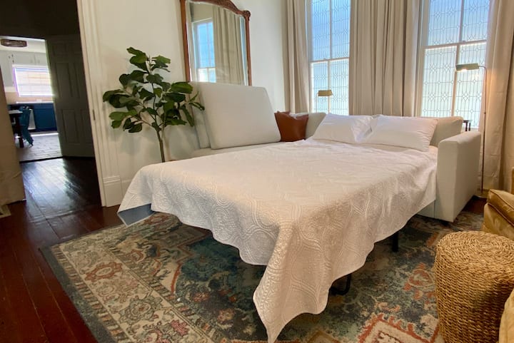 El sofá cama tamaño Queen tiene capacidad para 2 personas cómodamente.La mesa del sofá de detrás también tiene 2 estaciones de carga para mayor comodidad. La puerta de la habitación de la litera se cierra para mayor privacidad.