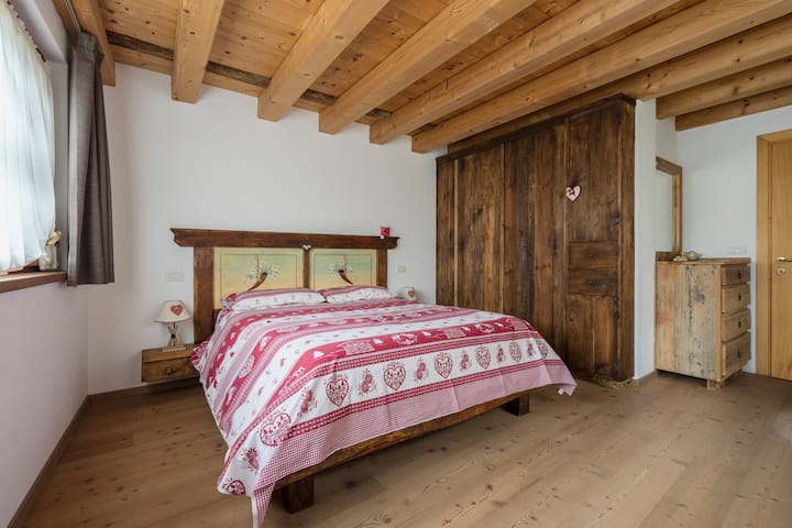 Собата има рустикален и пријатен стил, кој се карактеризира со доминантна употреба на природно дрво. Изложениот таван со греди и светлите дрвени подови создаваат топла и интимна атмосфера