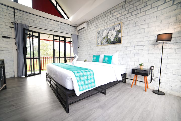Une chambre lumineuse et confortable avec un très grand lit, un balcon privé donnant sur des rizières et une déco de style industriel. Parfait pour une escapade paisible avec de la lumière naturelle, de l'air frais et une touche de charme rustique.