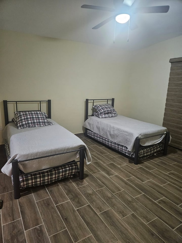 ห้องนอนกว้างขวางพร้อมเตียงเดี่ยว 2 เตียงแบบค้างคาวและตู้เสื้อผ้า เครื่องปรับอากาศ (เย็น/ร้อน) พัดลม