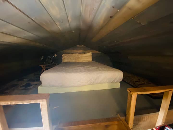 Dies ist das zweite Schlafzimmer, das ein großes Bett, einen Nachttischventilator und eine Nachttischlampe enthält.