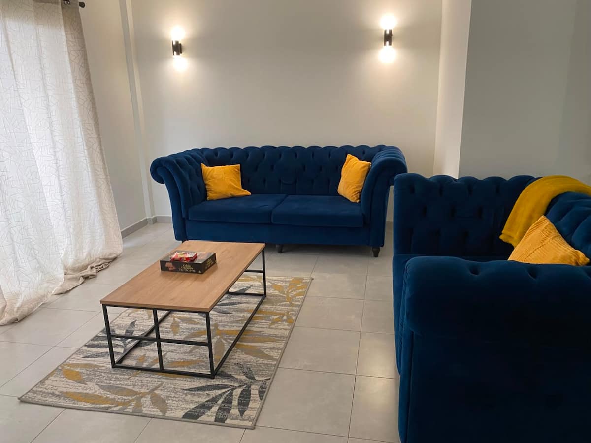Salon de l'appartement Akanda avec deux canapés bleus et table basse