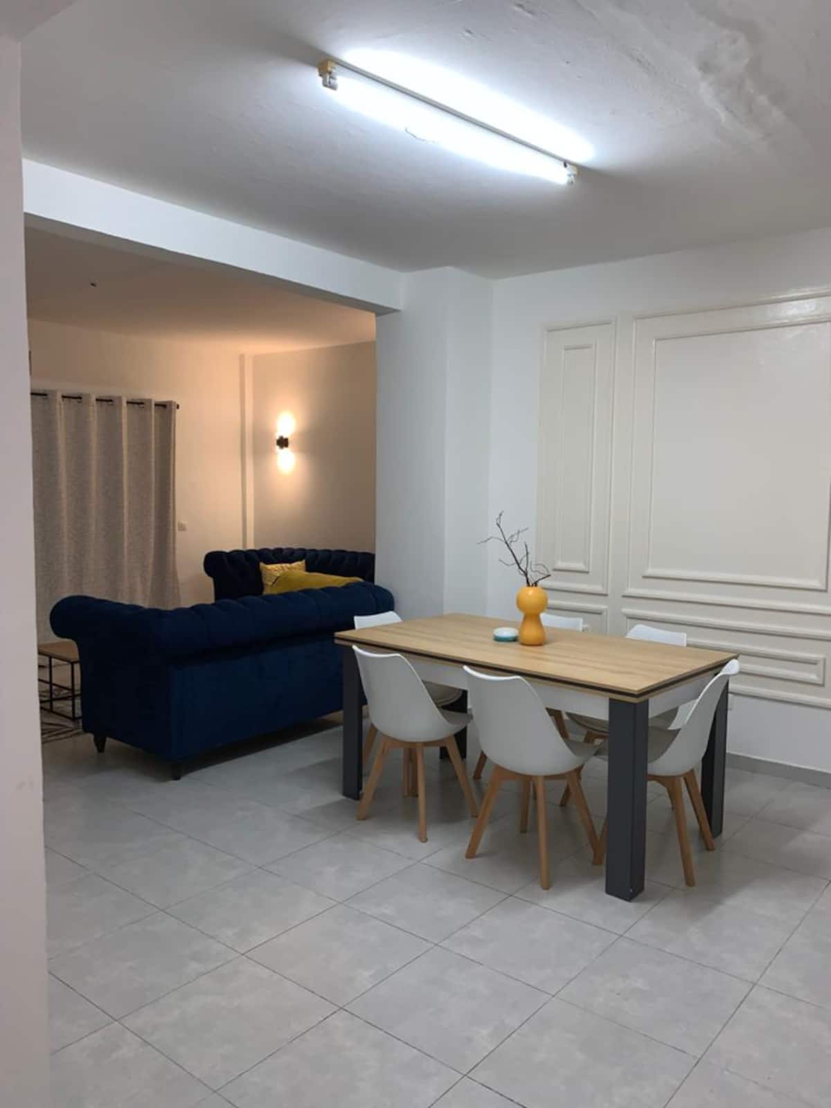 Salon de l'appartement d'Akanda avec balcon et vue sur la ville