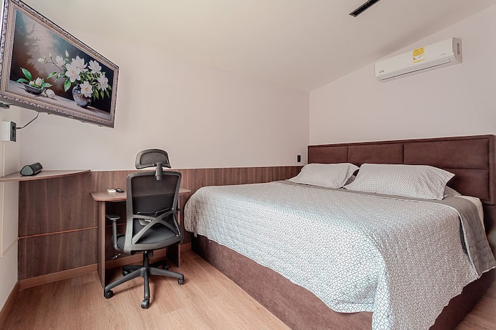 Habitación secundaria con cama king, aire acondicionado, escritorio de trabajo, televisión y espacio para guardar tu ropa 