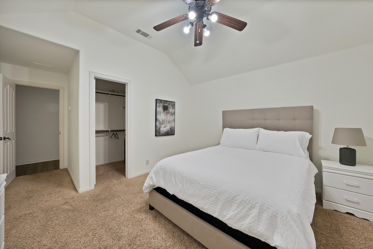 Bright room with a comfy queen bed and smart tv.