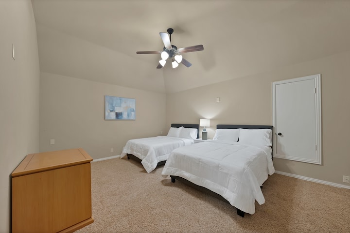Guest Room: Spacious retreat with two plush beds and artistic decor for restful nights!