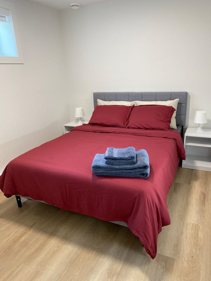 Útulná spálňa s prémiovou čerstvou posteľnou bielizňou, nočnými stolíkmi a lampičkami na oboch stranách postele, ktoré poskytujú jednoduchý prístup a pohodlie pre každého hosťa