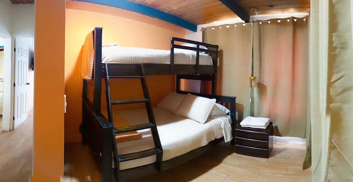 Troisième chambre avec un lit superposé, un lit double en bas et un lit impérial à l'étage.