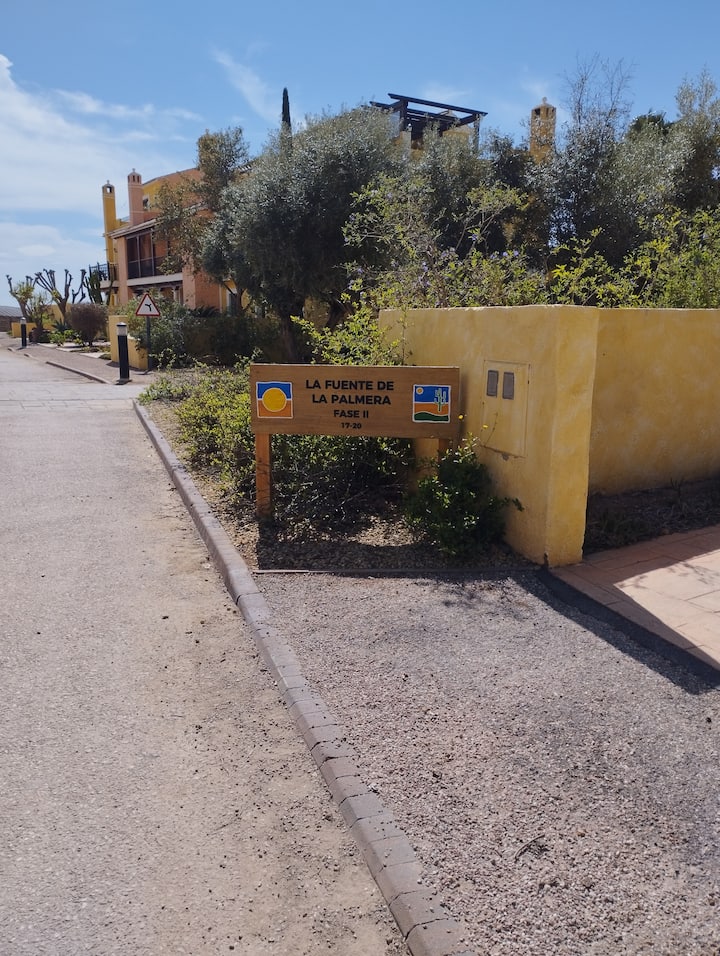 Senderos del resort señalizados entre jardines desérticos.