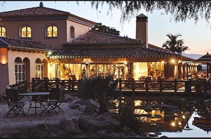 Casa Club y restaurante El Torrente iluminados al anochecer.
