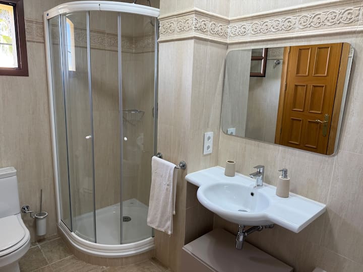 Gran baño en suite con ducha, bañera, bidé y ventana exterior.