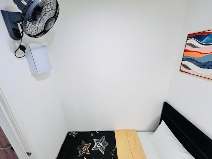 Prestavaná komora na spálňu s jednolôžkom a nástenným ventilátorom s diaľkovým ovládaním. 