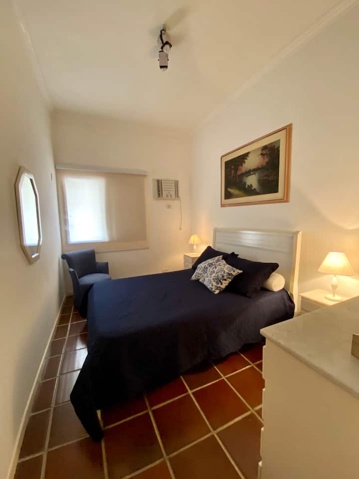 Dormitorio principal con aire acondicionado en la ventana.