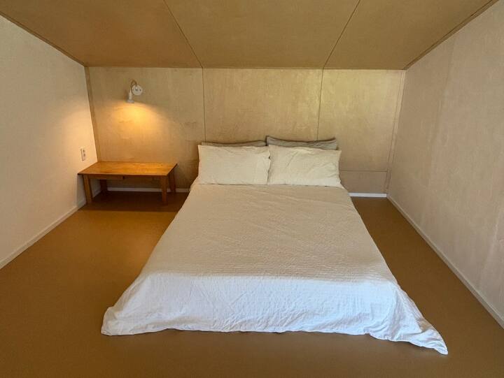 Საძინებელში დგას საწოლი 152 × 203 სმ.
Დამატებითი სტუმრებისთვის ჩვენ უზრუნველვყოფთ ერთ ბამბის საბანსა და საბანს.