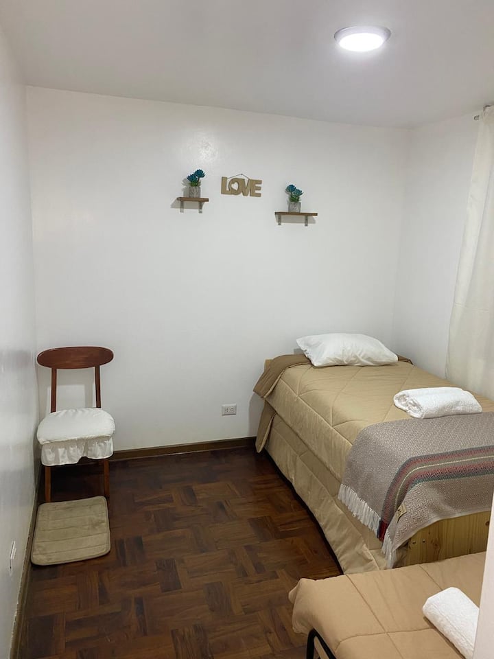 Habitación secundaria espacio cómodo y tranquilo para un buen descanso ✨. Cuenta con cama y cama auxiliar de 1.5 plazas confortable, y se puede acomodar una cama de 1 plaza cuenta con espacio para colocar maletas, colgar tu ropa y plancha para ropa.