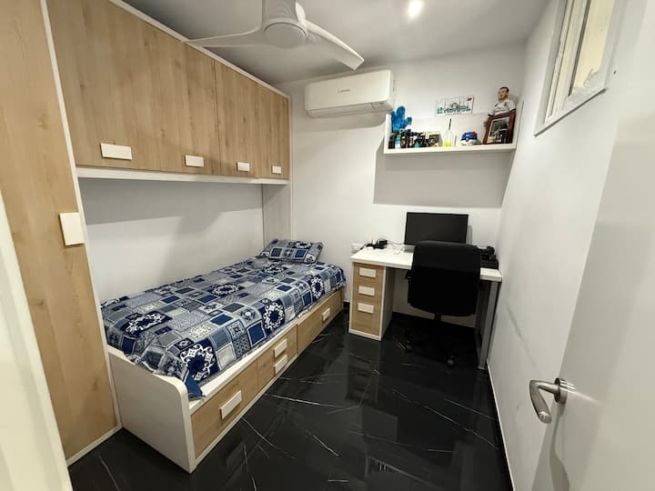 ห้องนอนเดี่ยวพร้อมเครื่องปรับอากาศที่อบอุ่นพร้อมตู้เสื้อผ้ากว้างขวางและโต๊ะทำงานเฉพาะ
