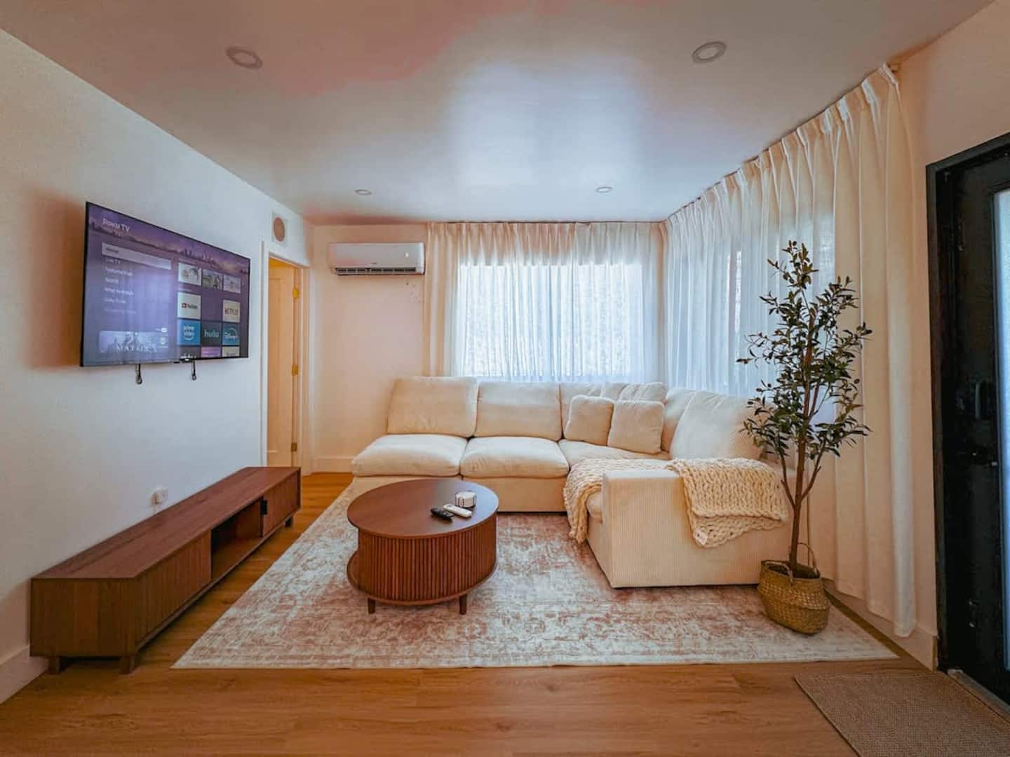 Casa Coco living room with cream sectional sofa and wood furnishings