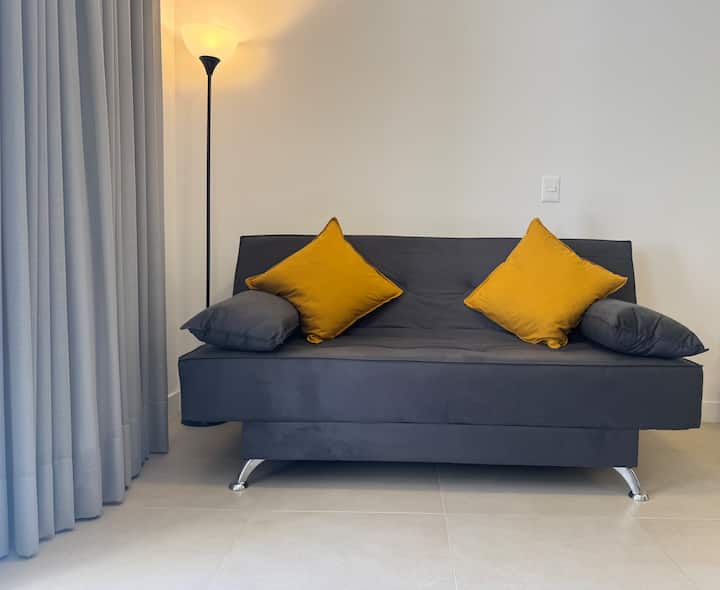 Sofá cama en la habitación con cortina opaca 